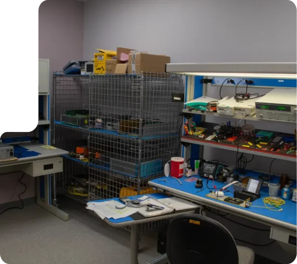 Electronics lab workspace with testing equipment, tools, and storage racks